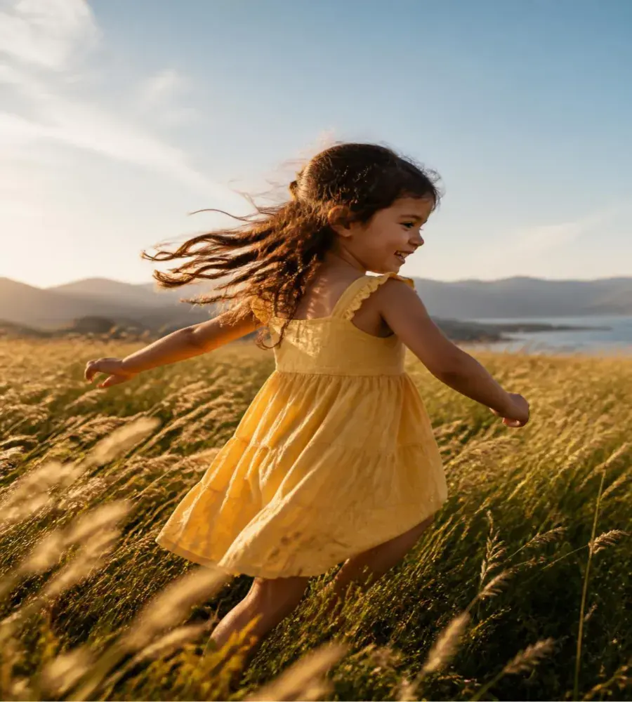 Building: a child in a yellow dress running through golden grass